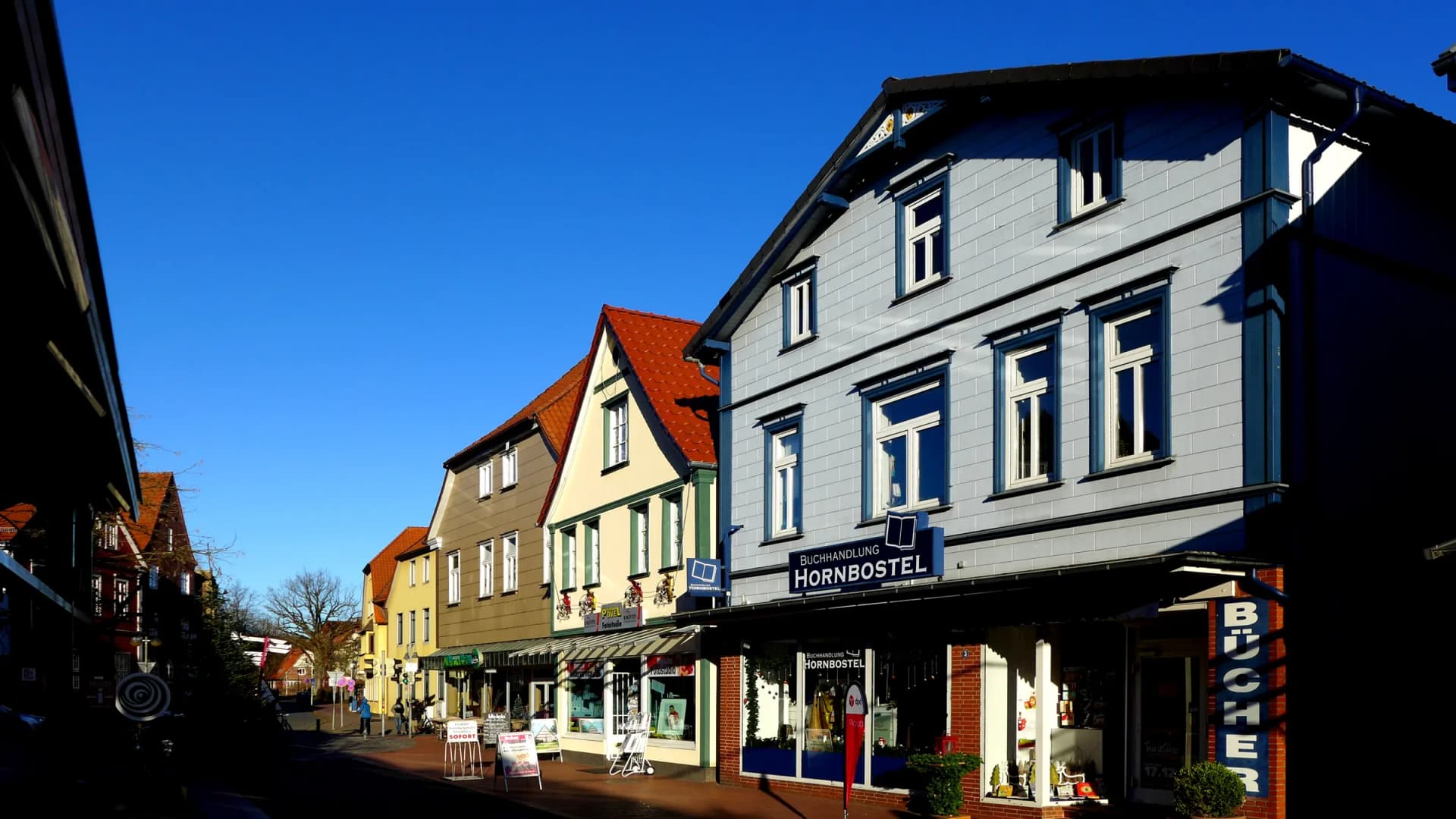 Geschäfte und Altbauten in der Marktstraße in Soltau bei blauem Himmel